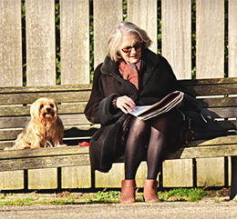 retired woman in park bench with dog